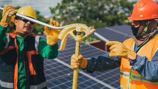 Professional solar panel installers working on a rooftop installation.